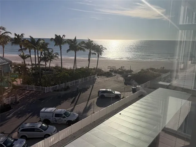 a view of a brick house with a large tree and flower plants
