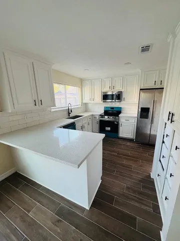 a kitchen with granite countertop a refrigerator stove top oven and sink