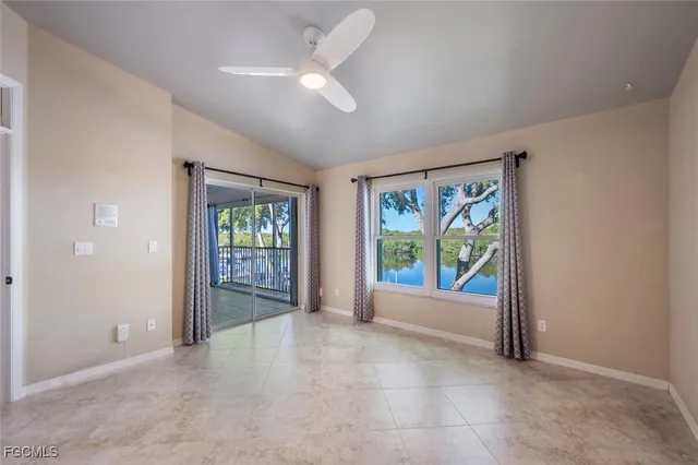 an empty room with windows fan and front door