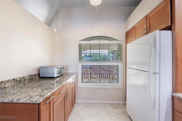 a kitchen with granite countertop a refrigerator and a sink