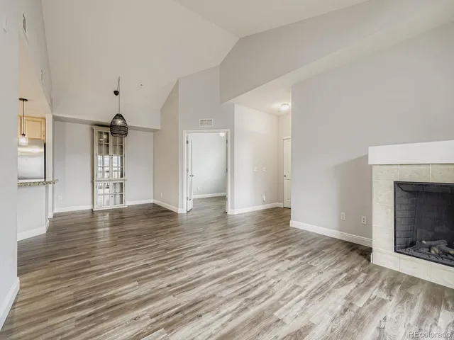 a view of empty room with wooden floor and fireplace