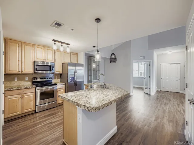 a kitchen with granite countertop a stove oven and refrigerator
