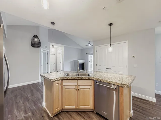 a kitchen with kitchen island a counter top space a sink stainless steel appliances and cabinets