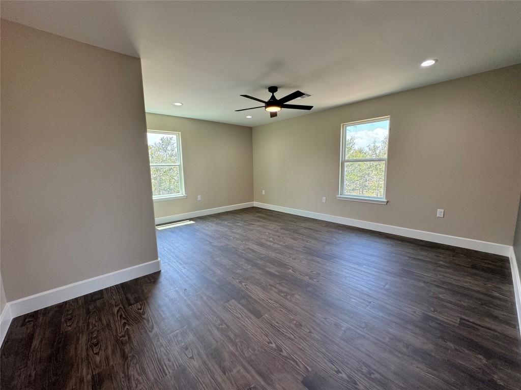 128 Passion Vine Rd Dale Dale, TX 78616 - Photo 22 of 30 an empty room with wooden floor a ceiling fan and windows