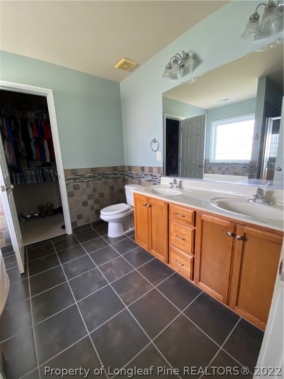 269 Declaration Drive Raeford, NC 28376 - Photo 13 of 26 a spacious bathroom with a granite countertop sink a mirror and a toilet
