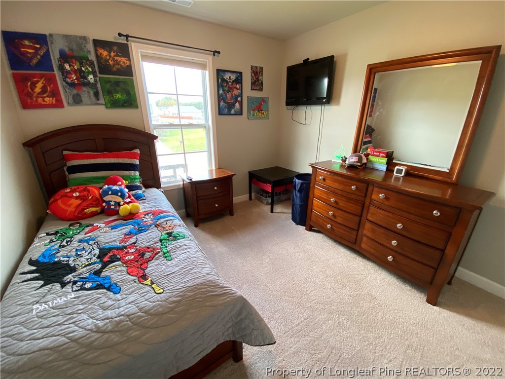 269 Declaration Drive Raeford, NC 28376 - Photo 17 of 26 a bedroom with a bed and flat screen tv