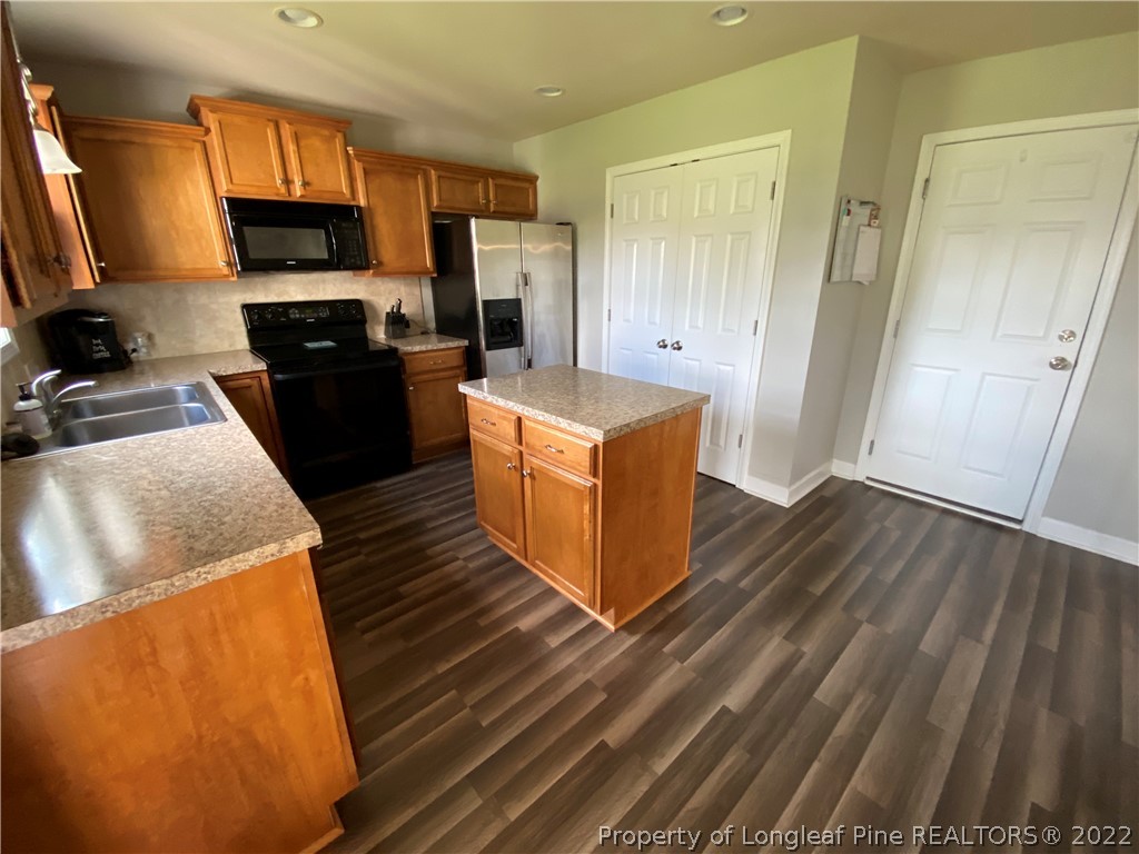 269 Declaration Drive Raeford, NC 28376 - Photo 5 of 26 a kitchen with stainless steel appliances wooden floors and wooden cabinets