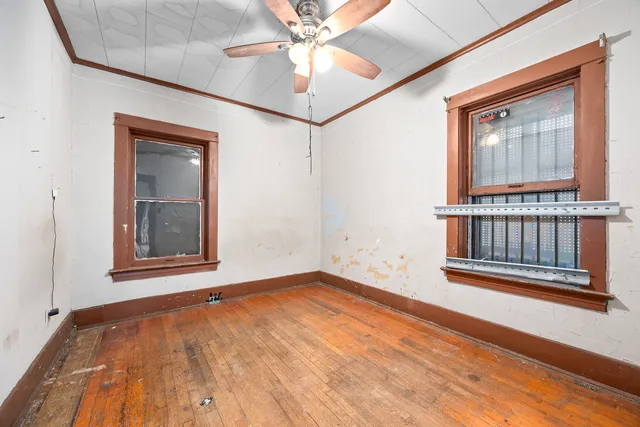 a view of an empty room with a window and wooden floor