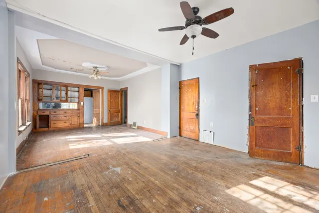 a view of an empty room with closet and a ceiling fan