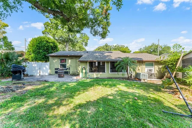 a front view of a house with table and chairs under an umbrella
