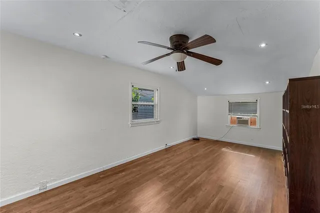 a view of a big room with wooden floor and windows