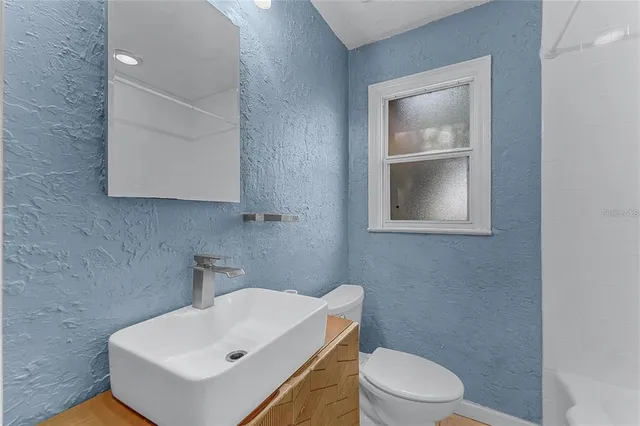 a bathroom with a sink a toilet and mirror