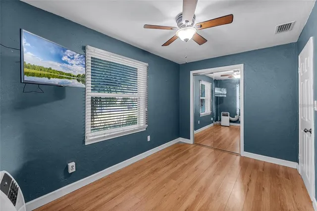 a view of a livingroom with wooden floor and a ceiling fan