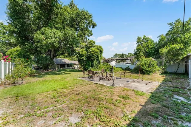 a view of a swimming pool with lawn chairs under an umbrella