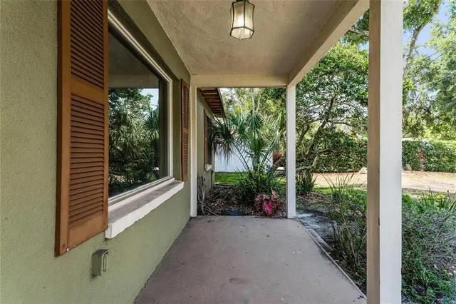 a view of a porch with furniture and garden