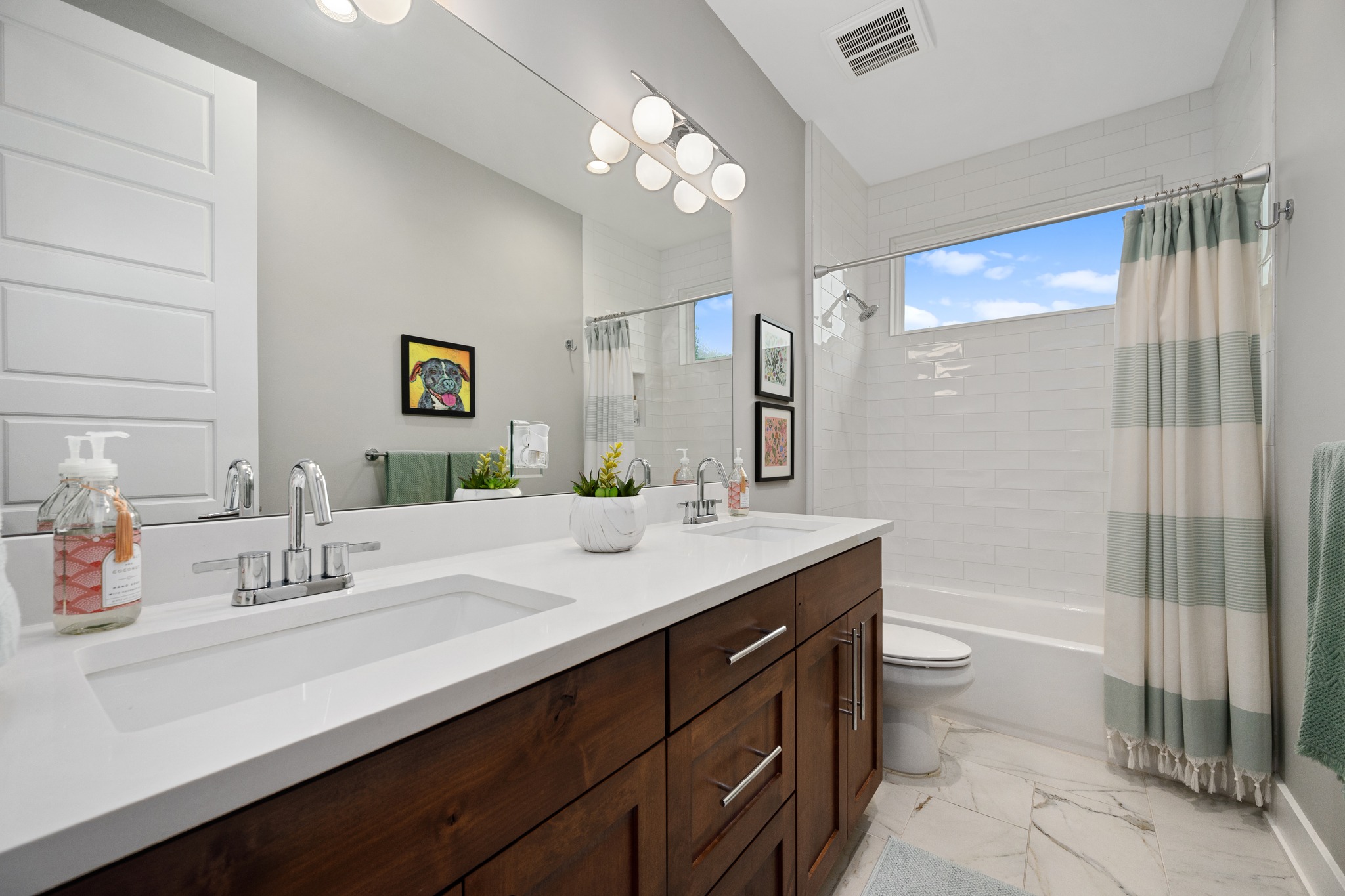 1103 Saucedo Street, Unit 1 Austin, TX 78721 - Photo 36 of 40 Dual vanities and a deep soaking tub create a luxurious daily routine in this well-appointed bathroom.