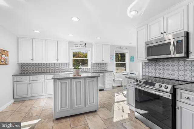 a kitchen with stainless steel appliances granite countertop a stove top oven a sink dishwasher and a microwave oven on the stove