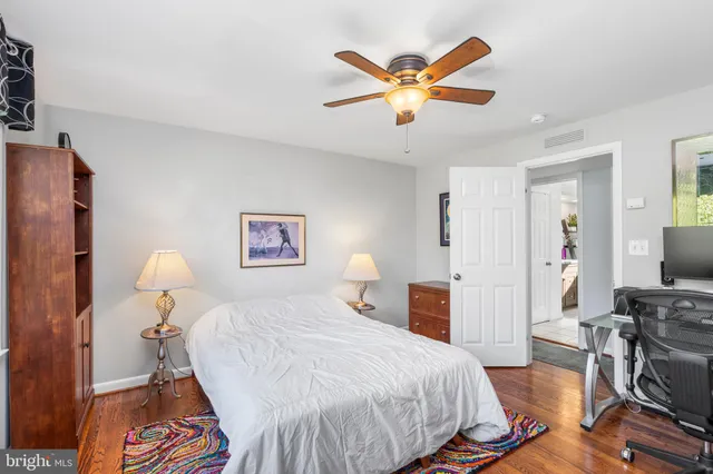 a bedroom with a bed and wooden floor