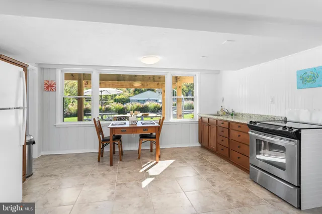 a kitchen with a stove a refrigerator and a dining table