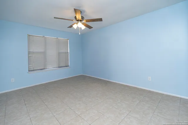 an empty room with a chandelier fan