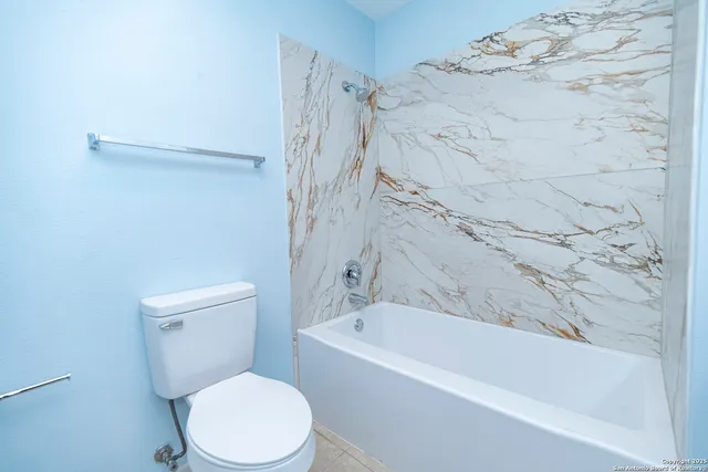 a white bath tub sitting next to a white toilet