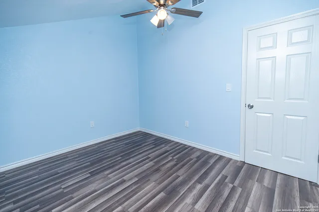 a view of an empty room with wooden floor
