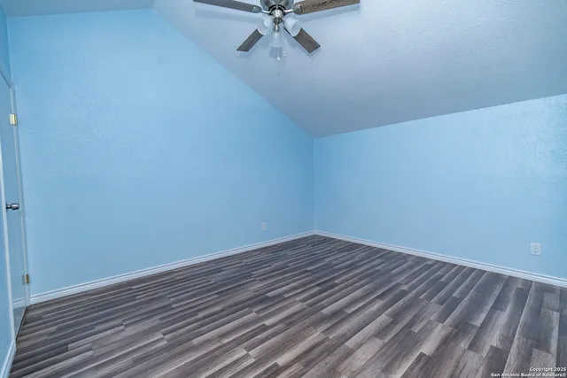 a view of a room with wooden floor and a ceiling fan