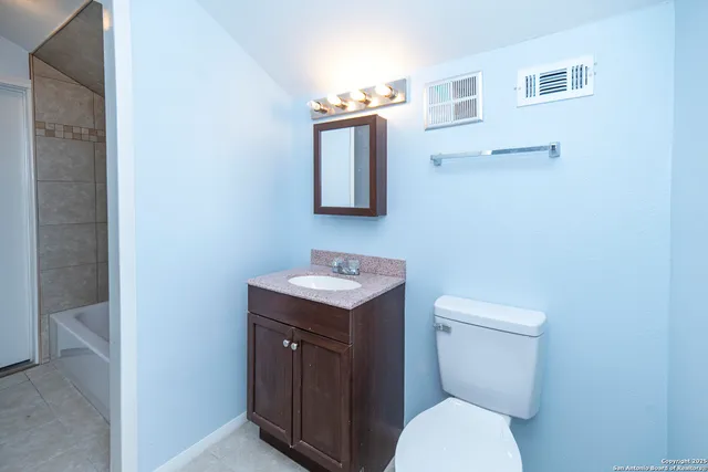 a bathroom with a toilet a sink and mirror
