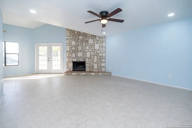 an empty room with fireplace and windows