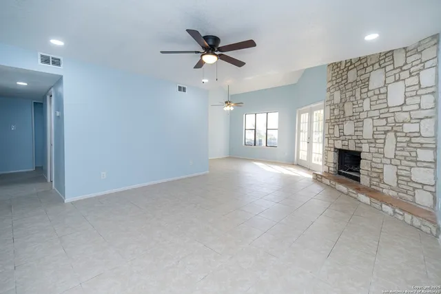 an empty room with fireplace and windows