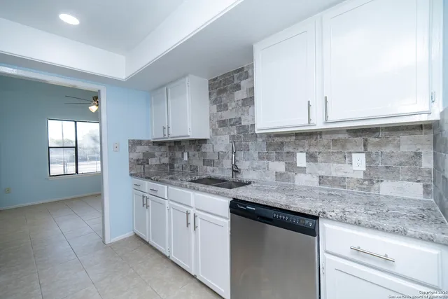 a kitchen with stainless steel appliances granite countertop a sink stove and cabinets