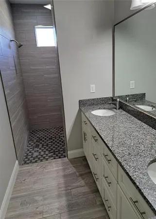 a bathroom with a granite countertop sink and a mirror
