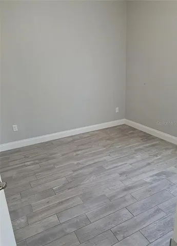 a view of an empty room with wooden floor