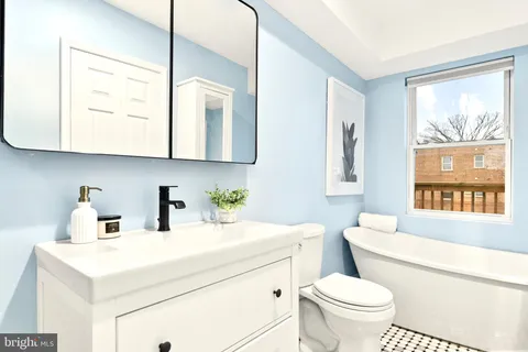 a bathroom with a sink a toilet and a mirror