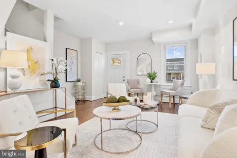 a living room with furniture a table and white walls