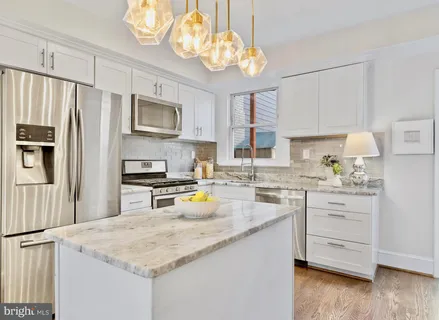 a kitchen with stainless steel appliances granite countertop a sink refrigerator stove and microwave