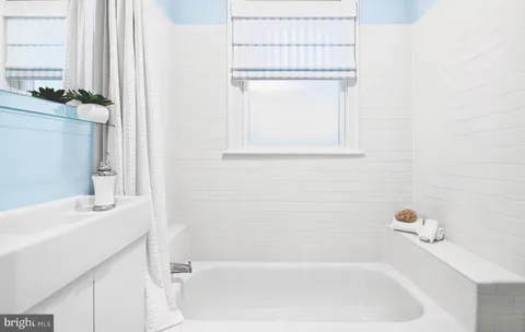 a bathroom with a tub sink vanity and a mirror
