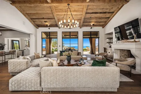 a kitchen with granite countertop a stove a sink dishwasher a dining table and chairs with wooden floor