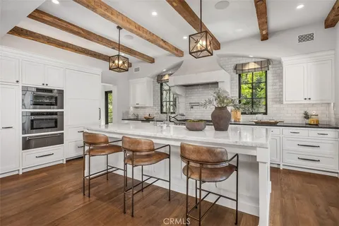 a large white kitchen with stainless steel appliances granite countertop lots of counter top space