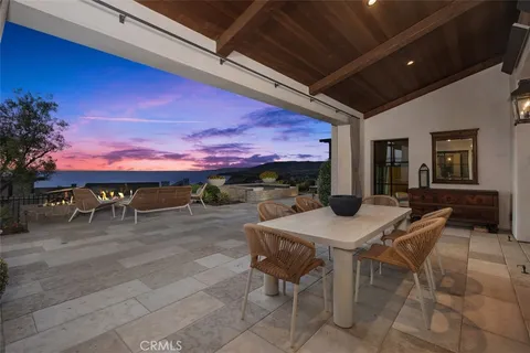 a view of a balcony with dining table & chairs