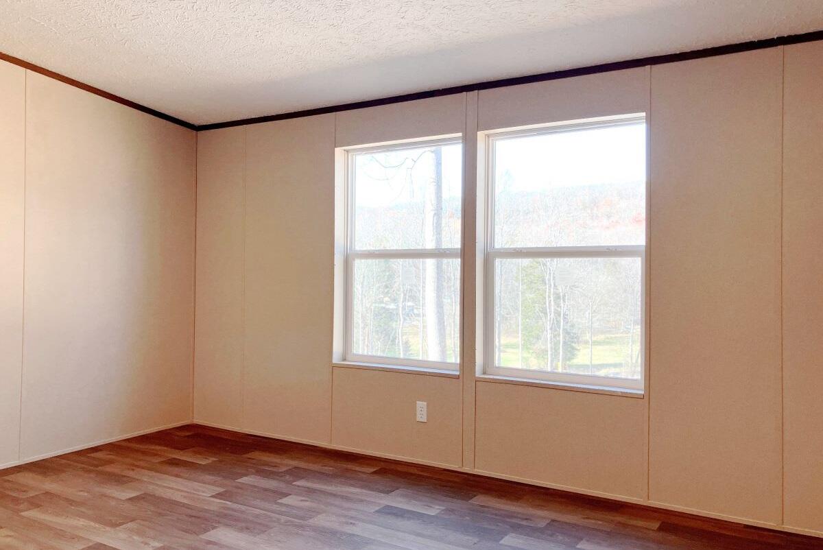 5489 Forge Road Glasgow, VA 24555 - Photo 12 of 38 an empty room with wooden floor and windows