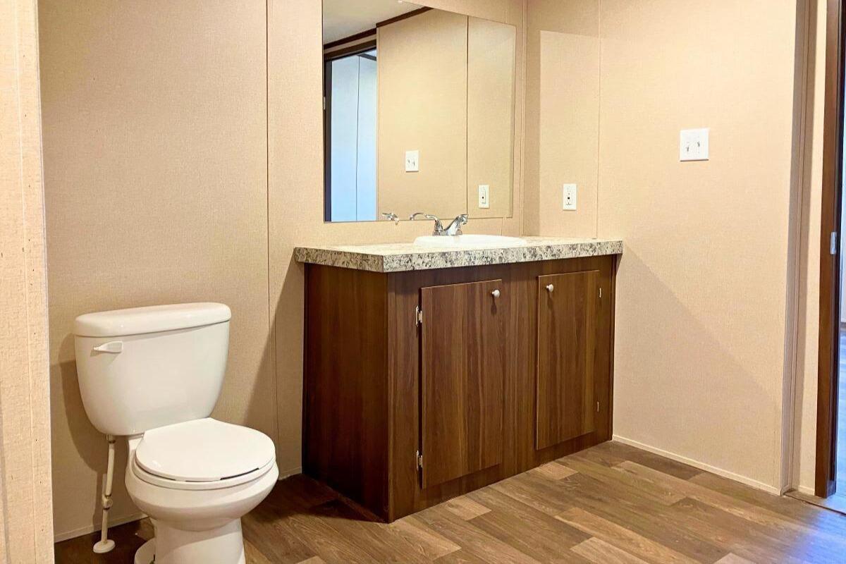 5489 Forge Road Glasgow, VA 24555 - Photo 14 of 38 a bathroom with a granite countertop toilet a sink and a mirror