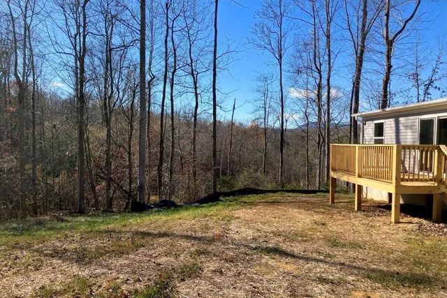 a view of a yard with wooden fence