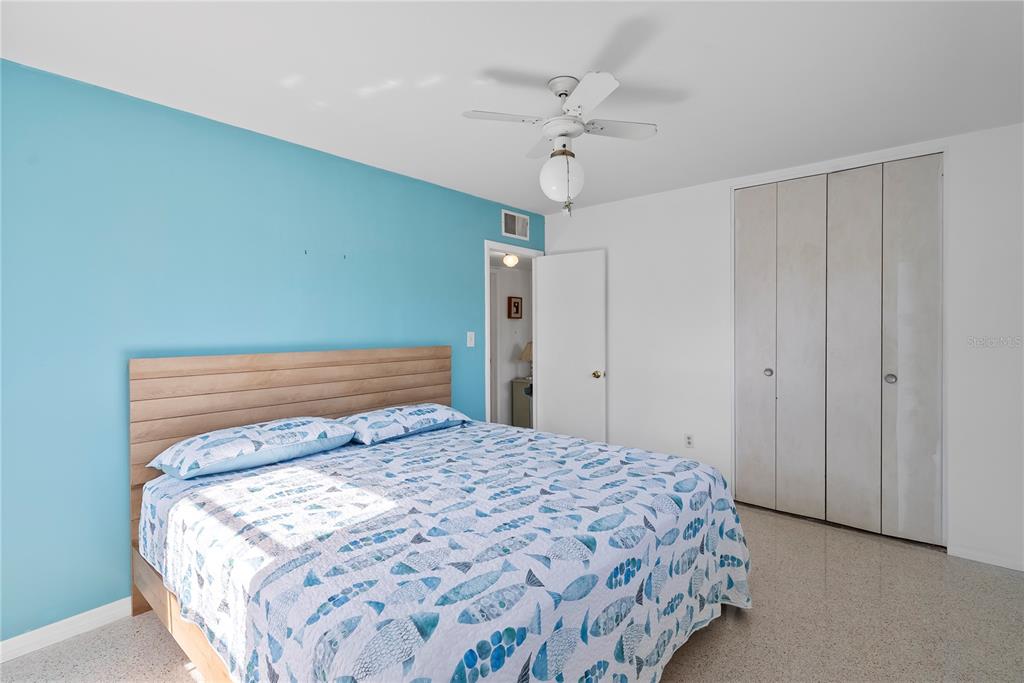 10609 Raffia Drive Port Richey, FL 34668 - Photo 14 of 24 a bedroom with a large bed and a chandelier