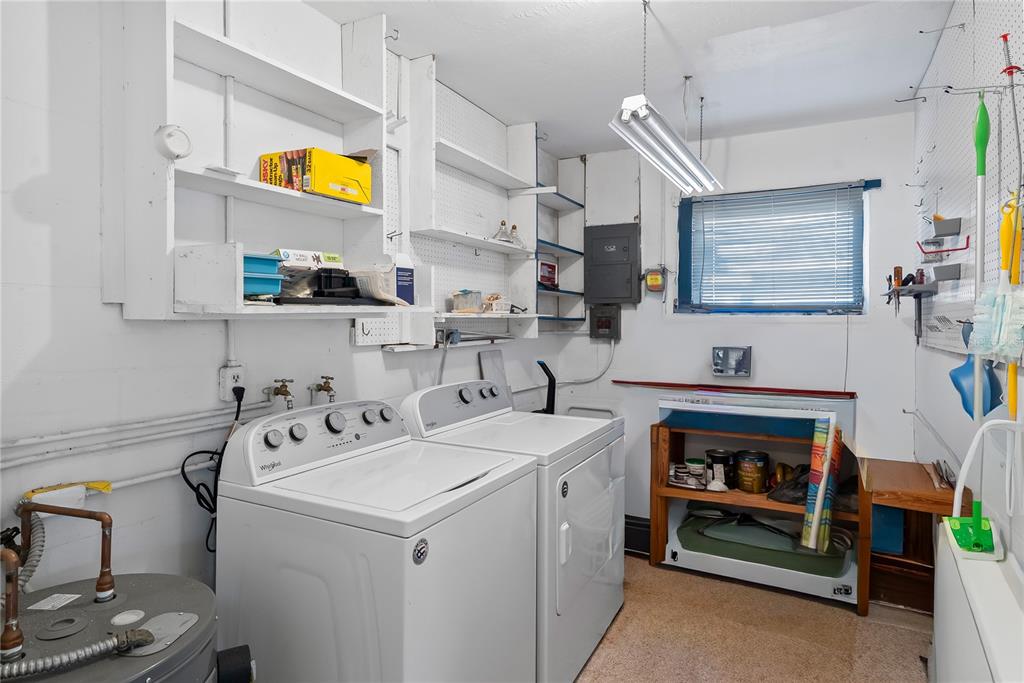 10609 Raffia Drive Port Richey, FL 34668 - Photo 18 of 24 a utility room with cabinets dryer and washer