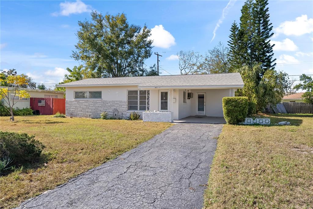 10609 Raffia Drive Port Richey, FL 34668 - Photo 22 of 24 a front view of a house with a yard and garage