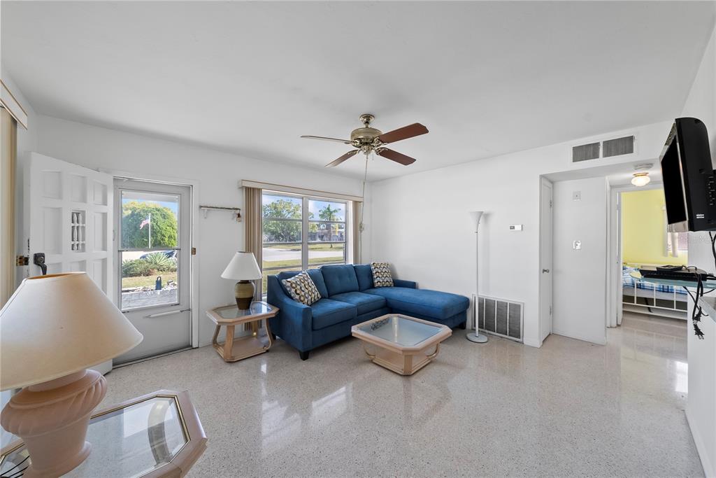 10609 Raffia Drive Port Richey, FL 34668 - Photo 4 of 24 a living room with furniture a ceiling fan a flat screen tv and a window