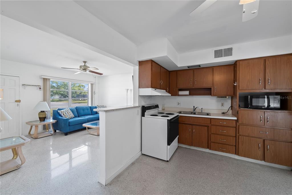 10609 Raffia Drive Port Richey, FL 34668 - Photo 9 of 24 a kitchen with stainless steel appliances granite countertop a stove top oven a sink a refrigerator and white cabinets