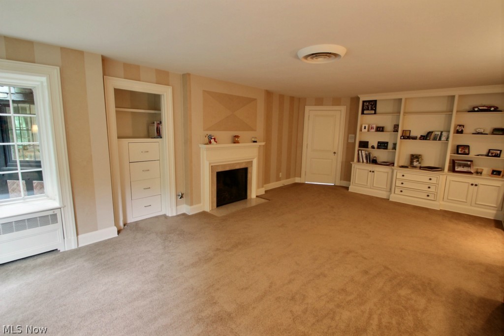 7450 Markell Road Willoughby, OH 44094 - Photo 13 of 25 Bedroom with fireplace and wall of built-in book shelves