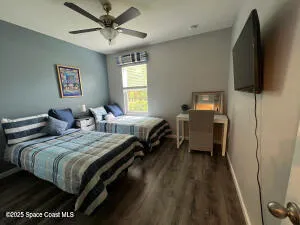 a bedroom with bed tv and window